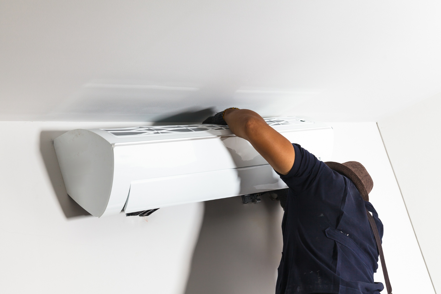 Technician performing AC maintenance services on a residential unit in Delaware homes.